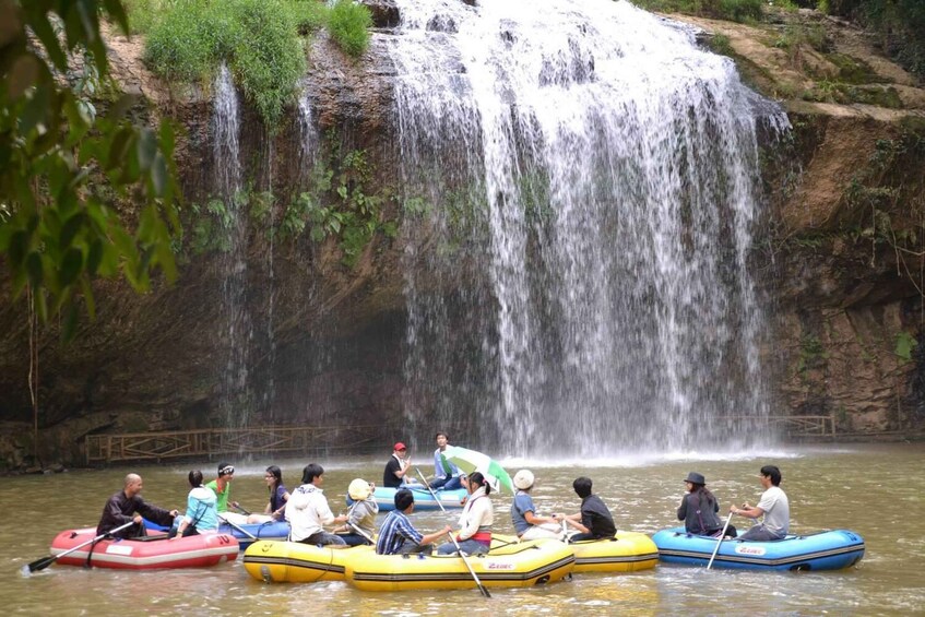 People rafting on a river with a waterfall in the background. 3