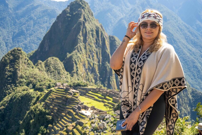 A person standing in front of Machu Picchu with a mountainous landscape in the background. 3