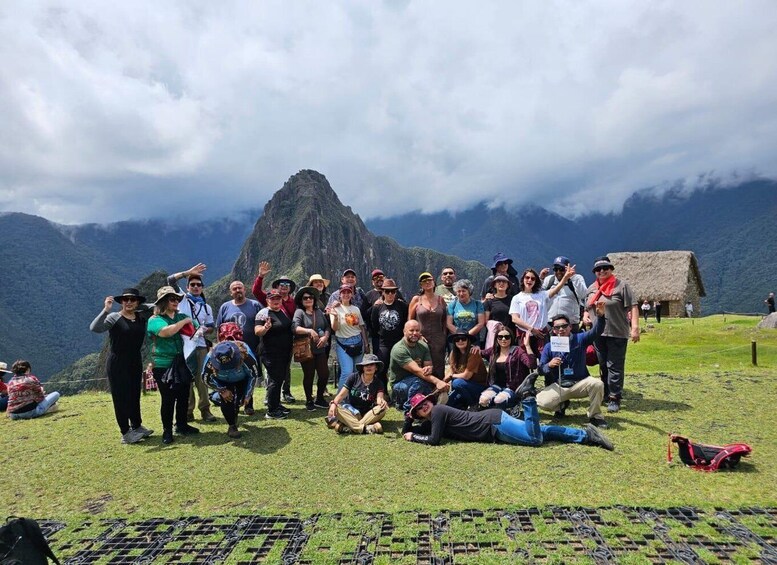 A group of people gathered on a grassy field with a mountain in the background. 1