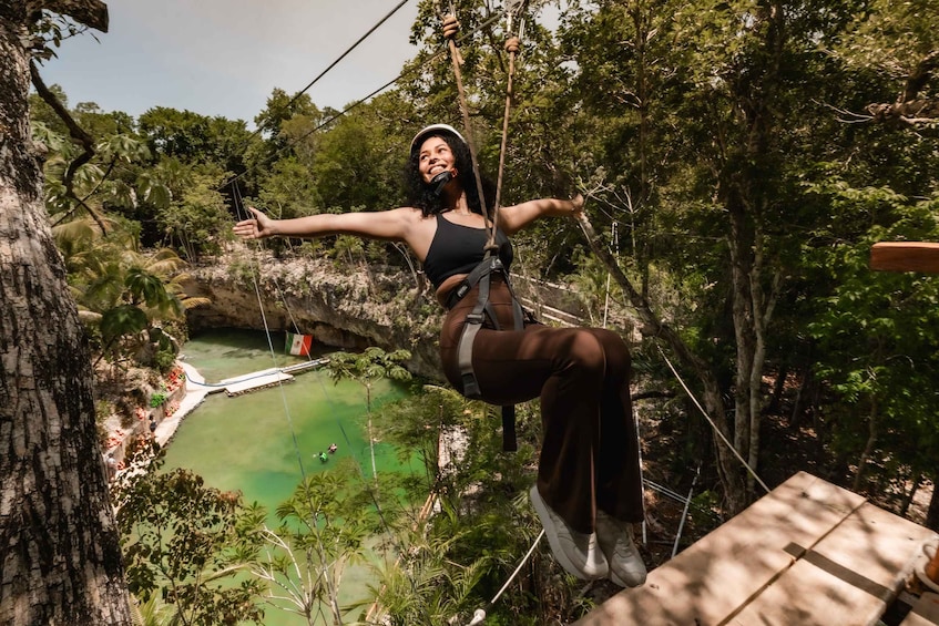 A person zip-lining through a forested area with a river and a bridge in the background. 2