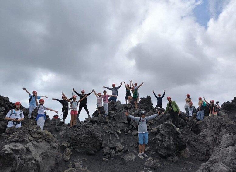 A group of people celebrating on a rocky mountain peak. 5