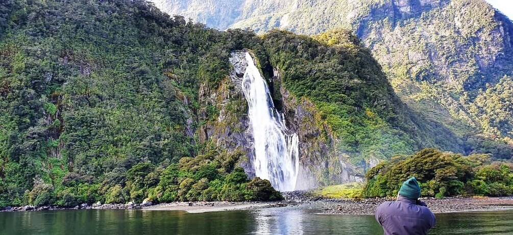 A waterfall cascading down a lush green mountain. 4
