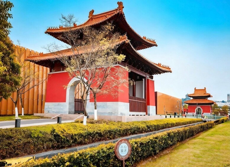 A traditional Chinese building with a red and white facade, a curved roof, and a small pagoda in the background. 3