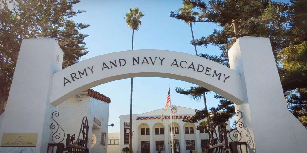 The entrance to the Army and Navy Academy with a white archway and an American flag. 5