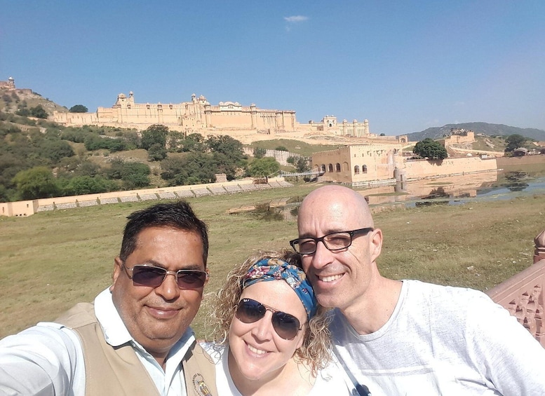 A group of people taking a selfie with a historic fort in the background. 1