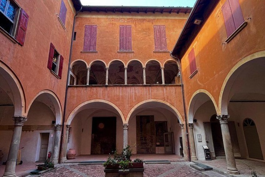 A courtyard with arches, columns, and a tiled floor. 3