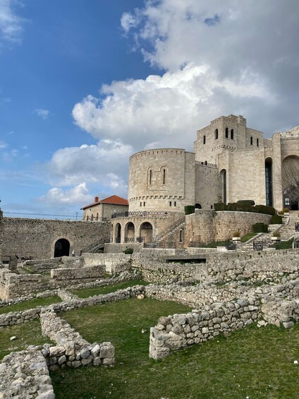 A historic stone fortress with a large central tower, arched gateways, and a surrounding moat. 3