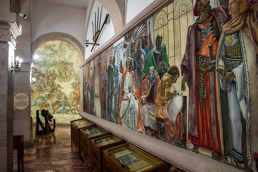 A church interior with a large fresco mural depicting biblical scenes and figures. 5