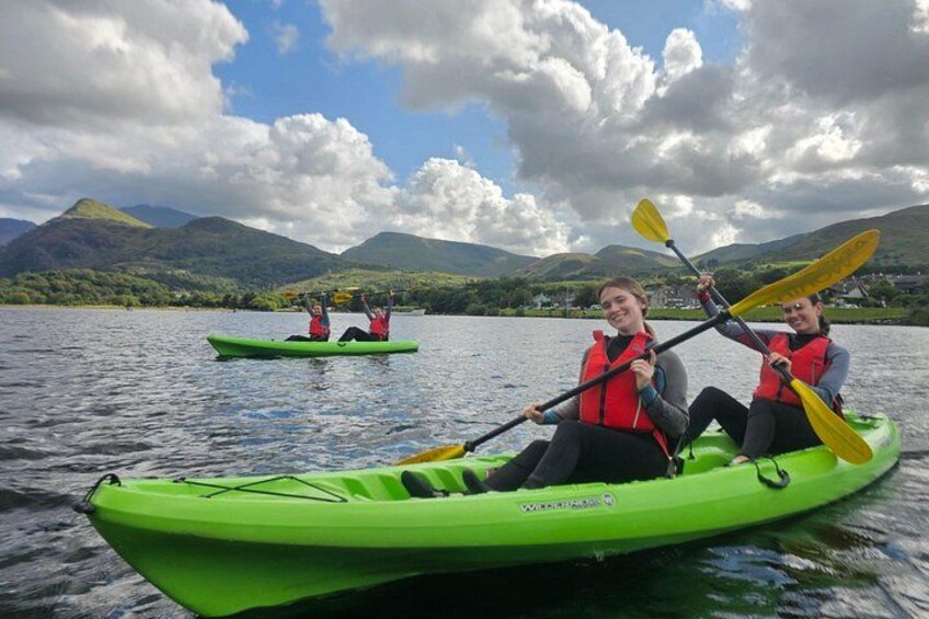 Dos personas kayakando en un lago con montañas al fondo. 1