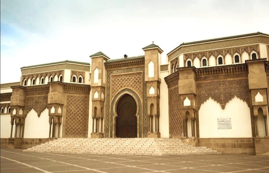 A large, ornate building with a central archway, detailed carvings, and a series of steps leading up to the entrance. 4