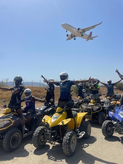 People on ATVs with an airplane flying overhead. 4