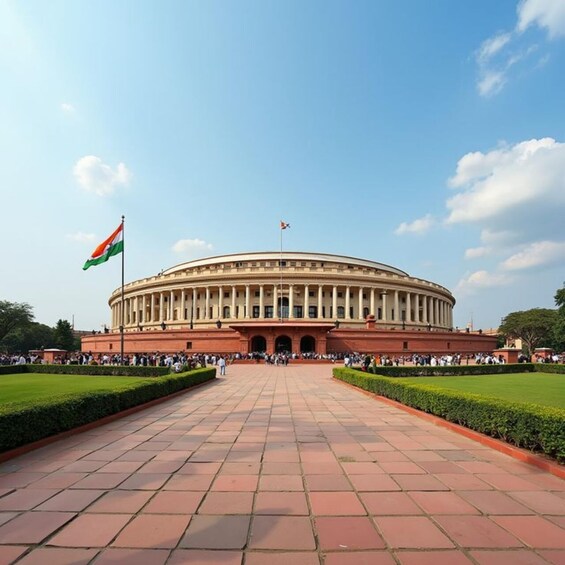 A large circular building with a flag on top, surrounded by a paved walkway and greenery. 4