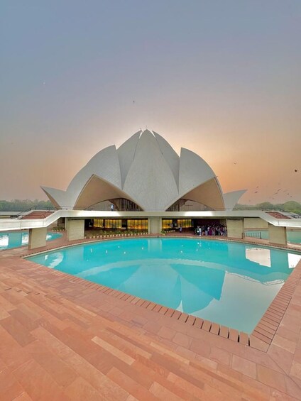 A lotus-shaped building with a pool in front. 5