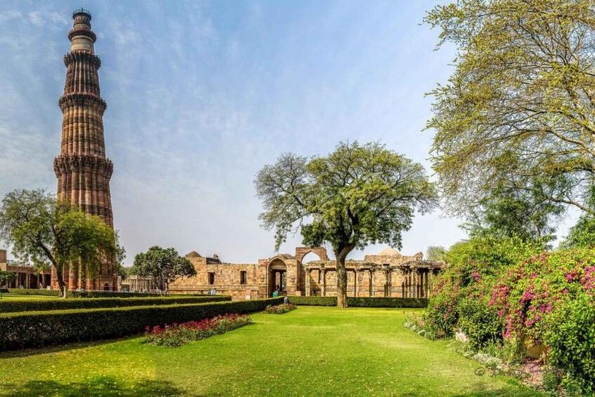The Qutub Minar, a historic tower, surrounded by well-maintained gardens and trees. 2