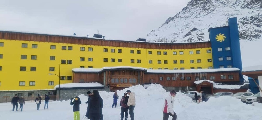 A yellow building with a blue tower, surrounded by snow. 1