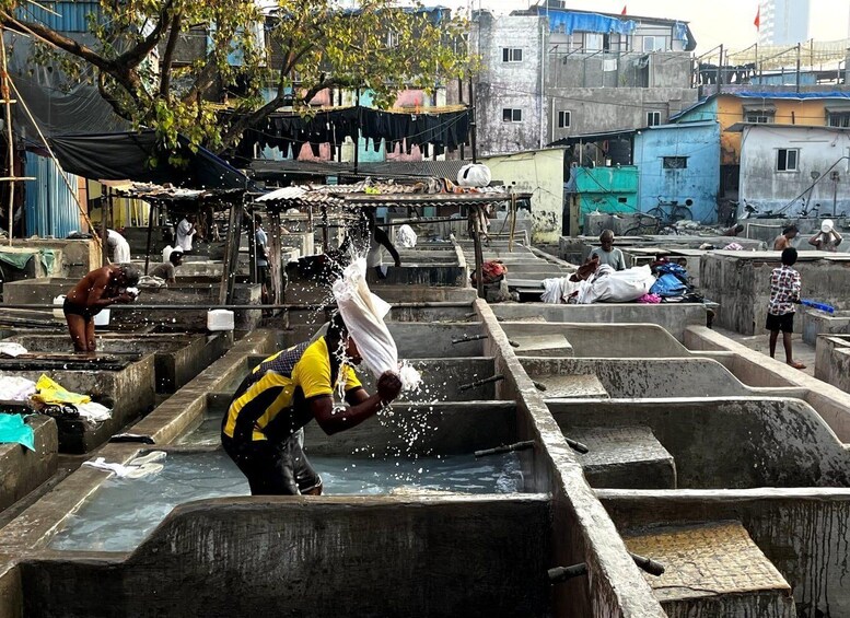 A man washing clothes in a water-filled basin. 5
