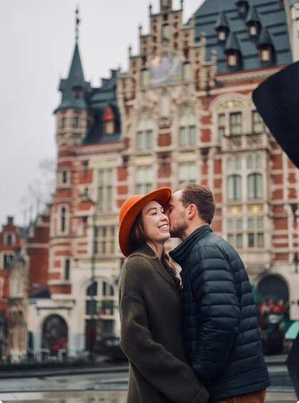 A couple embracing in front of a historic building with ornate architecture. 5