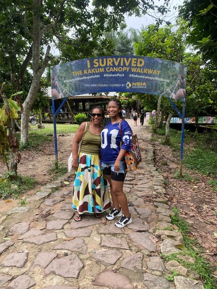 Two people standing under a canopy walkway sign. 4