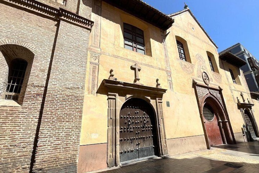 A historic building with a large arched entrance, a clock, and a bell tower. 5