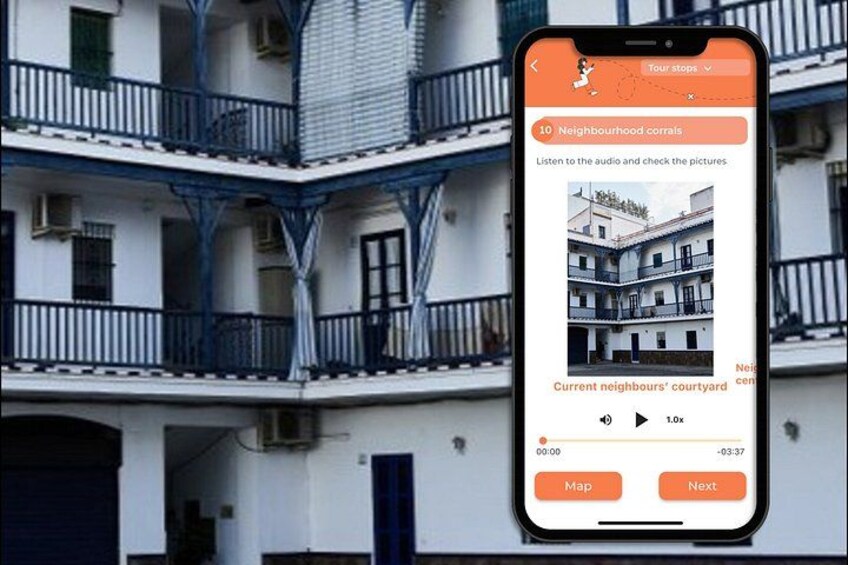 Ein Smartphone zeigt eine Touren-App, im Hintergrund ein Gebäude. 4