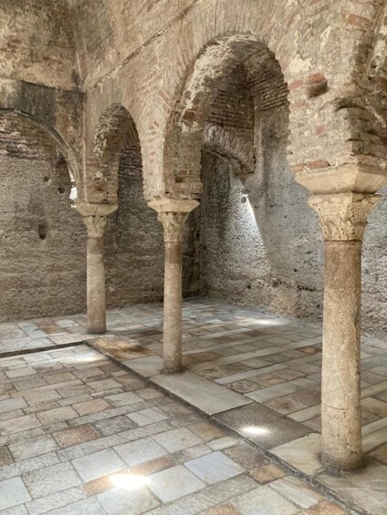 An ancient stone structure with arches and columns. 5