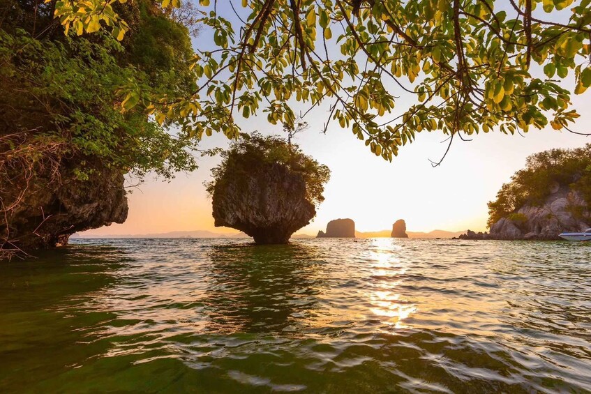 A coastal landscape with a large rock formation in the water, surrounded by lush greenery and a clear sky. 3