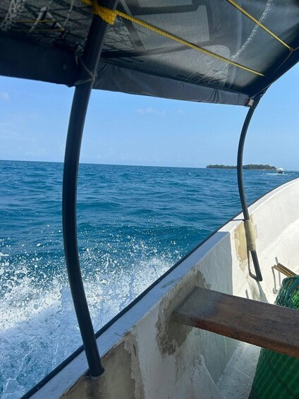 A boat's interior with a view of the ocean and a distant island. 3