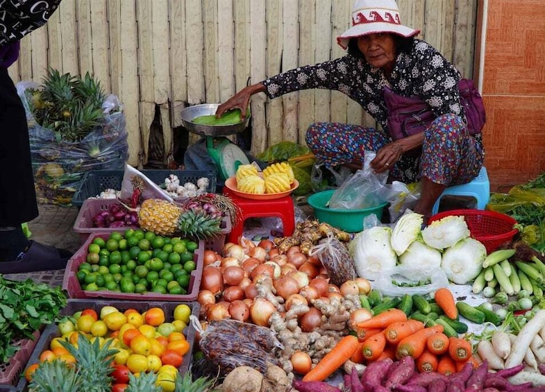 A vendor selling a variety of fresh produce at an outdoor market. 4