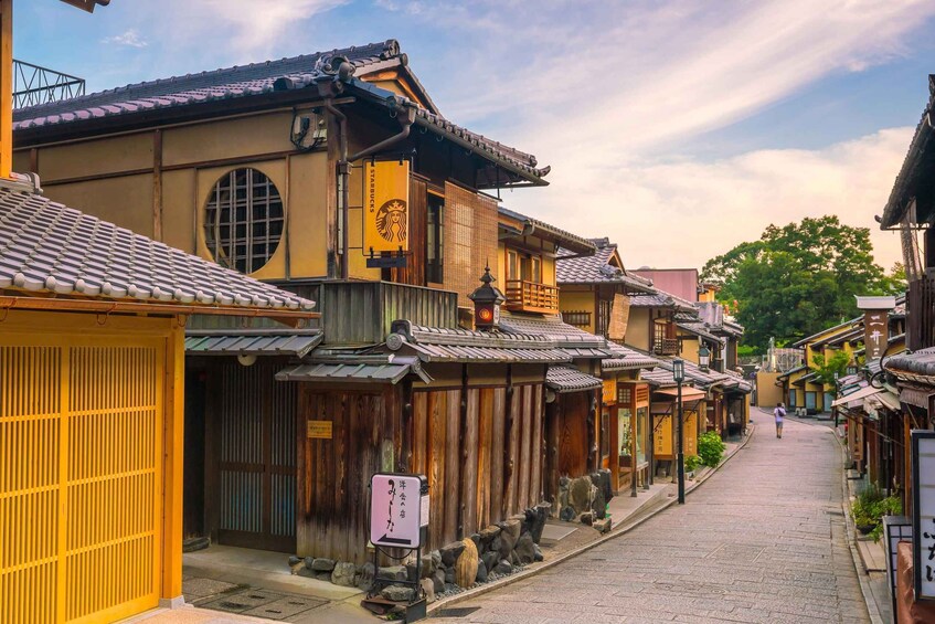 A traditional Japanese street with wooden buildings and a Starbucks sign. 5
