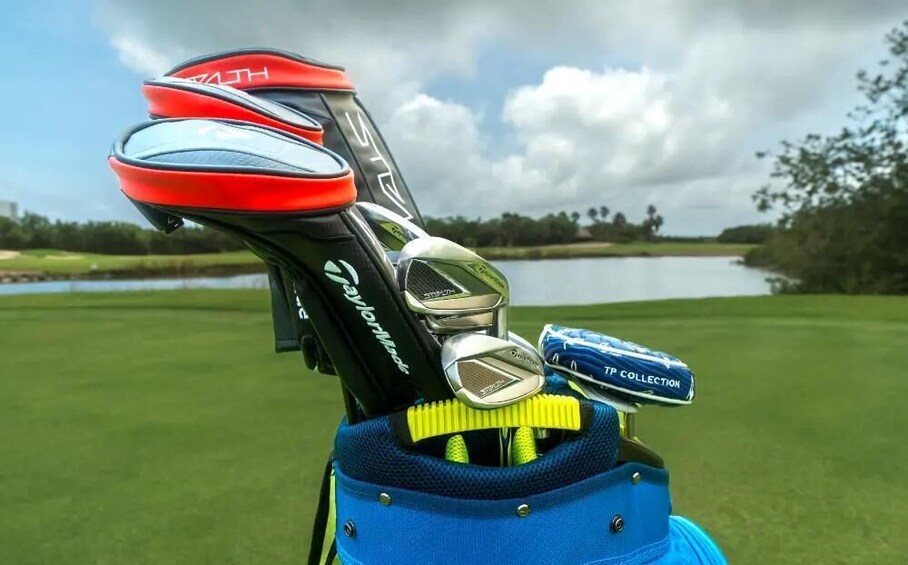 A golf bag with multiple clubs, a blue cap, and a scenic golf course in the background. 4