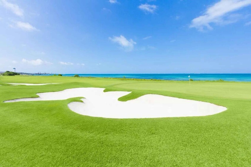 A golf course with sand bunkers and a clear blue sky. 2