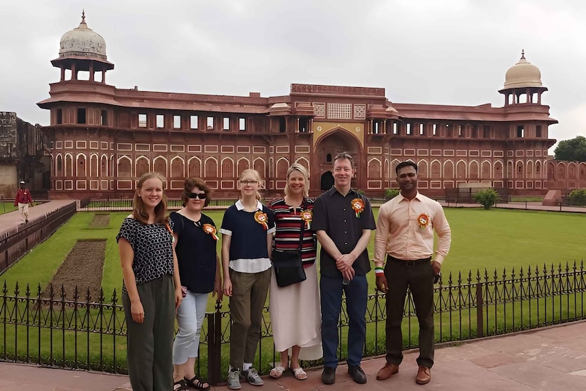 A group of people standing in front of a large, historic building with domes and arches. 5