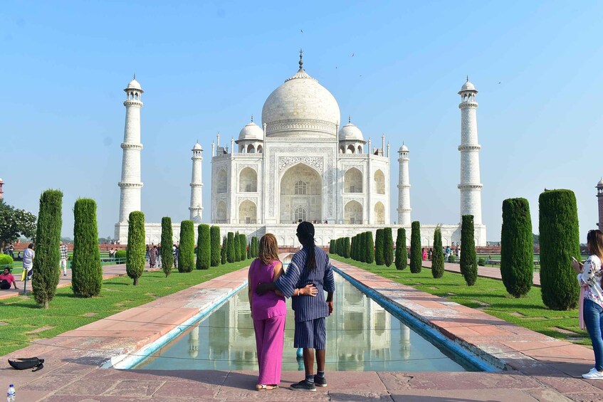 The Taj Mahal with two people standing in front of it. 1
