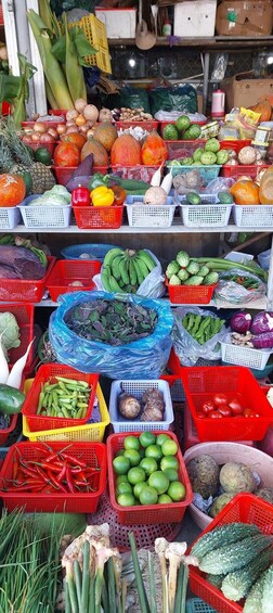 A market stall with various fruits and vegetables displayed in baskets and crates. 2