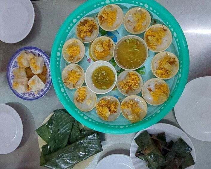 A plate of food with dumplings and a bowl of sauce. 1