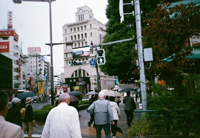 A busy urban street with pedestrians, traffic lights, and buildings. 1