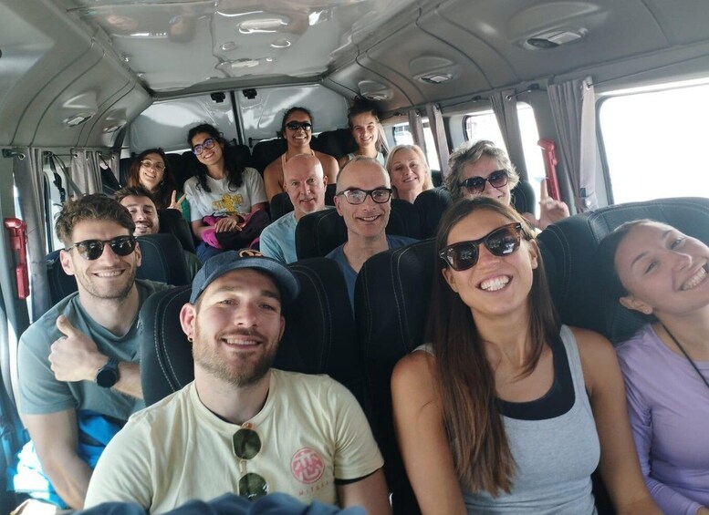 A group of people seated inside a vehicle. 5