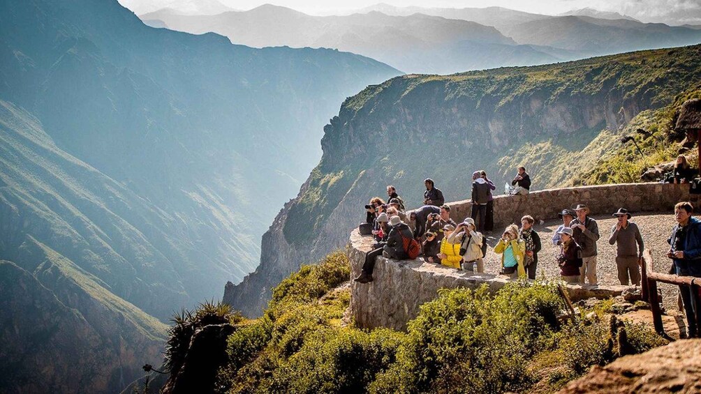 A group of people on a mountain ridge overlooking a valley. 1