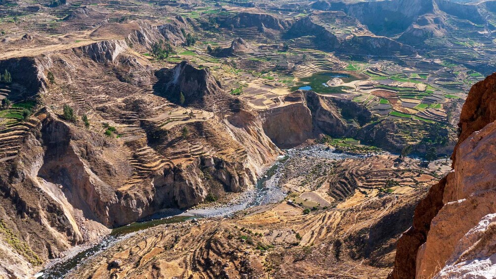 Terraced agricultural fields in a mountainous region with a river flowing through. 2