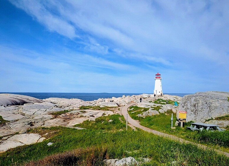 A lighthouse on a rocky coastline with a clear sky. 4