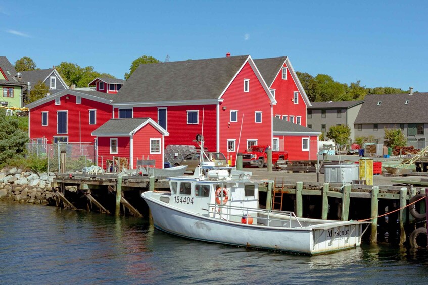 A red house, a white boat, and a dock. 2