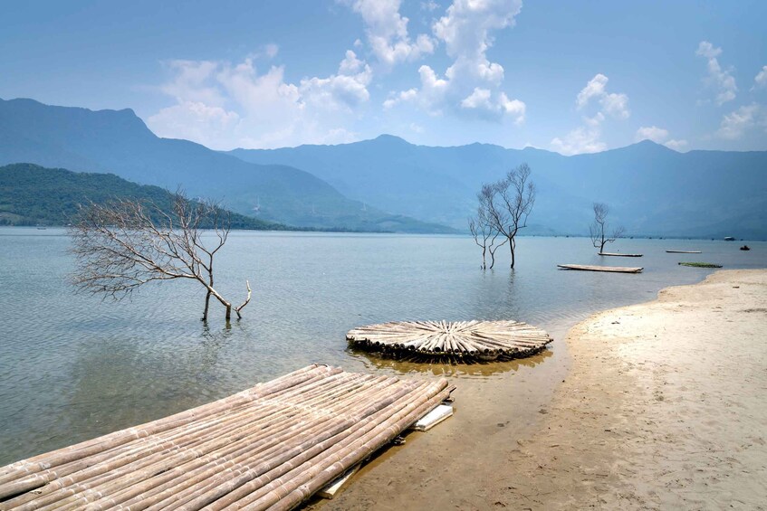 A calm lake with clear water, surrounded by mountains and a wooden dock extending into the water. 4