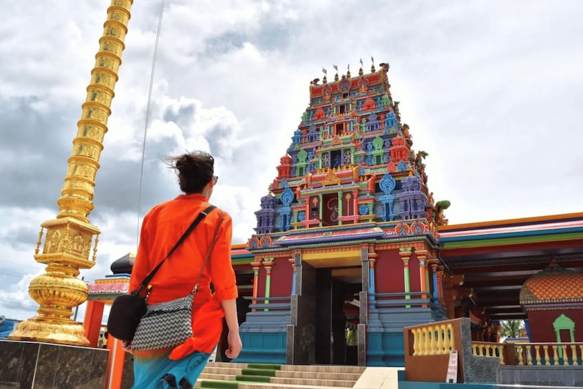 A colorful temple with a tiered roof and a golden pillar. 1