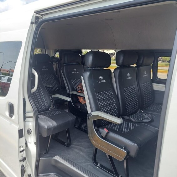 A white van interior with black Hiace branded seats and a visible dog in the back. 3