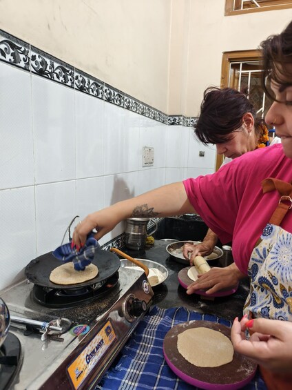 Two people preparing food on a kitchen counter. 5
