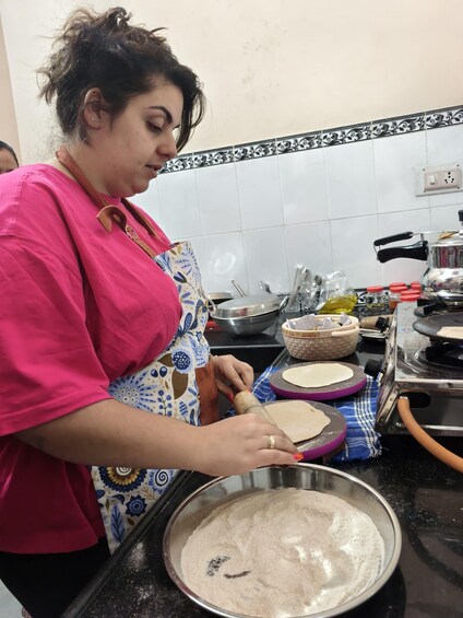 A person rolling dough on a kitchen counter. 2