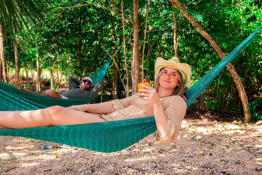 Two people relaxing in a hammock in a forested area. 3
