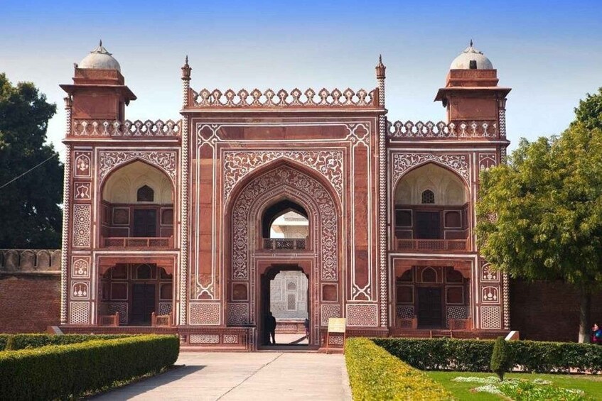 A large, ornate red and white building with a central archway and two domed towers. 3