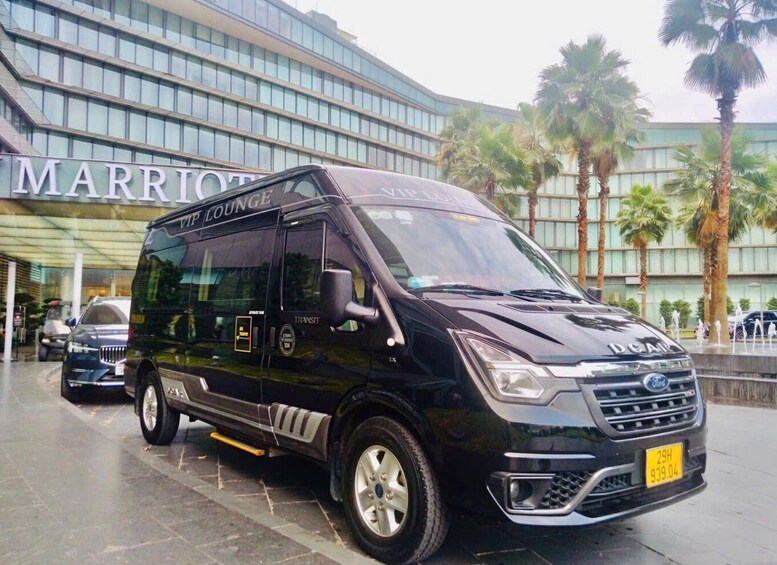 A black van parked in front of a building with a sign that reads "MARRIOTT LOUNGE". 1