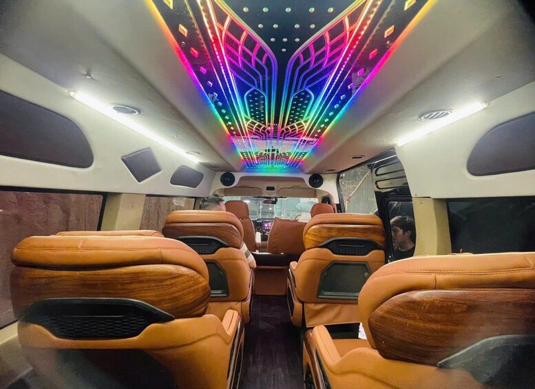 A vehicle interior with leather seats and a ceiling with colorful LED lights. 5
